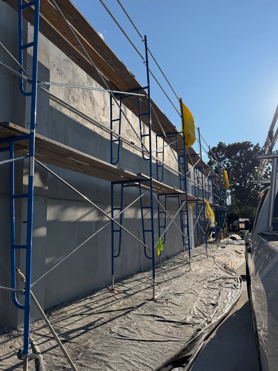 Smooth grey stucco wall with scaffolding
