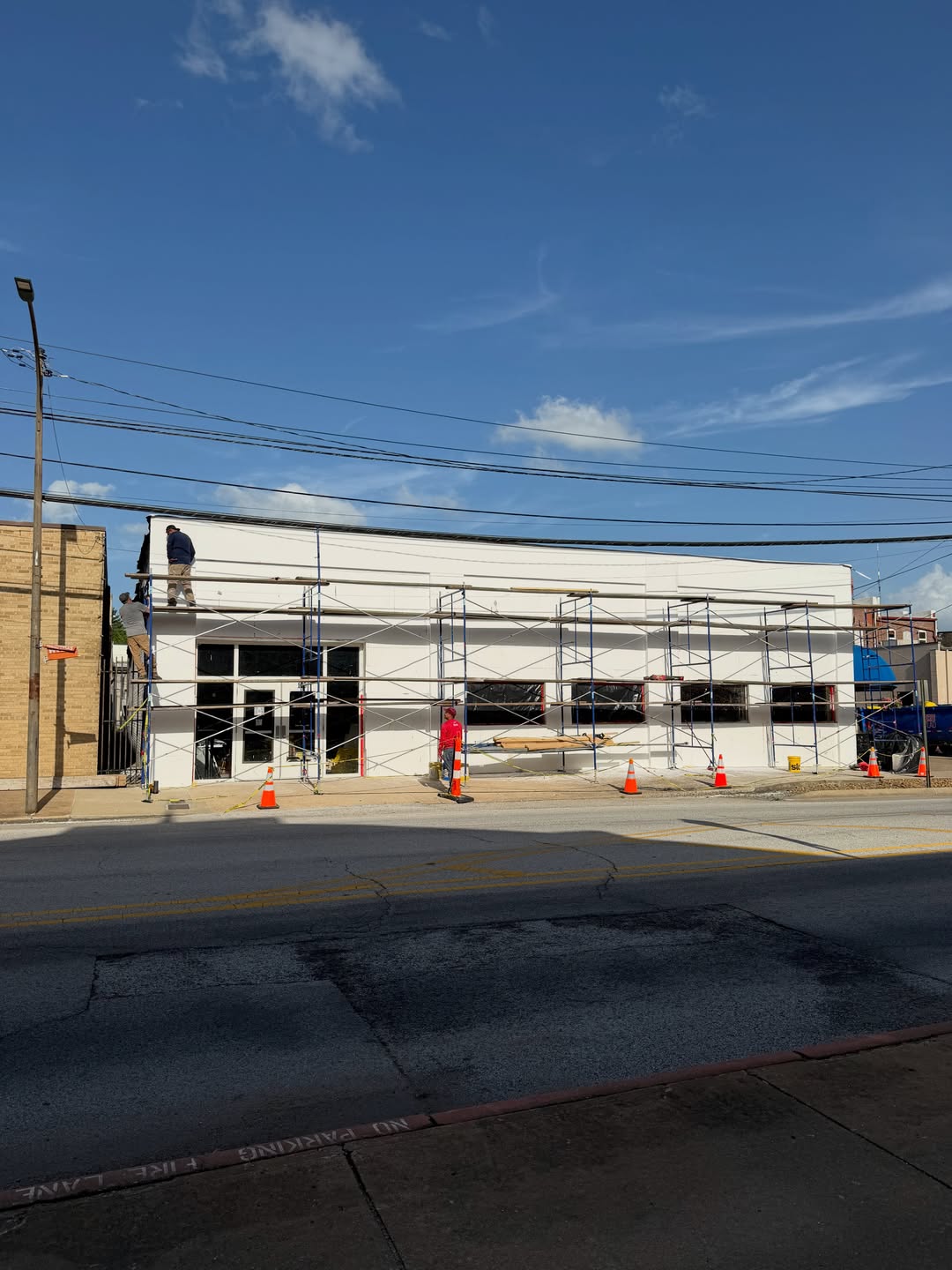 White stucco storefront with scaffolding on job site
