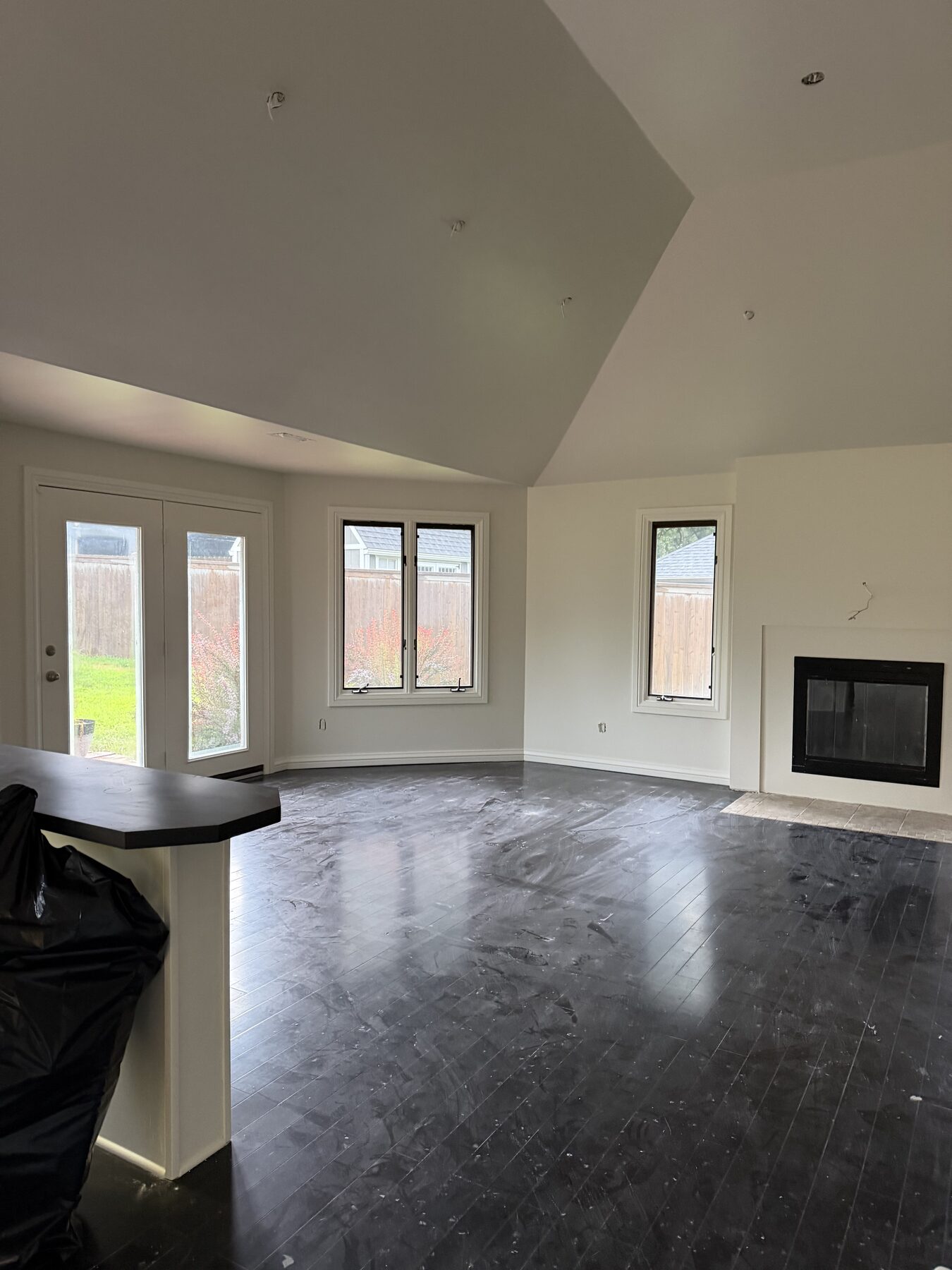 Freshly painted open living area with vaulted ceiling and fireplace